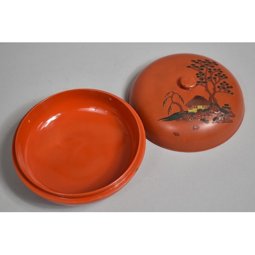 96 - A Japanese Circular Lacquered Box, The Lid Decorated in Relief with House and Trees. 16cms Diameter