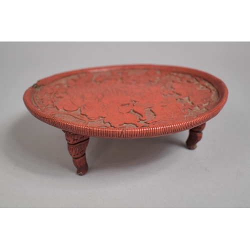 97 - A Japanese Red Cinnabar Circular Card Tray on Three Feet. Decorated in Relief with Figures Dancing i... 