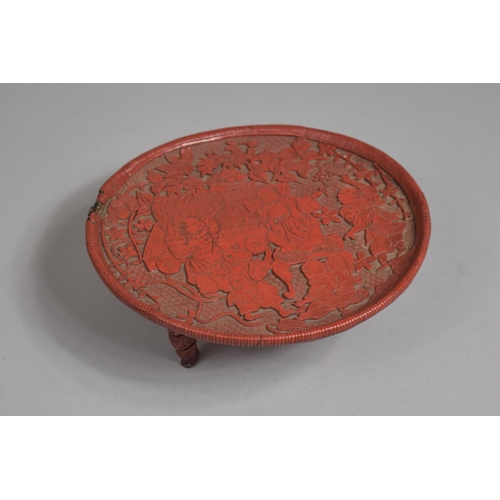 97 - A Japanese Red Cinnabar Circular Card Tray on Three Feet. Decorated in Relief with Figures Dancing i... 