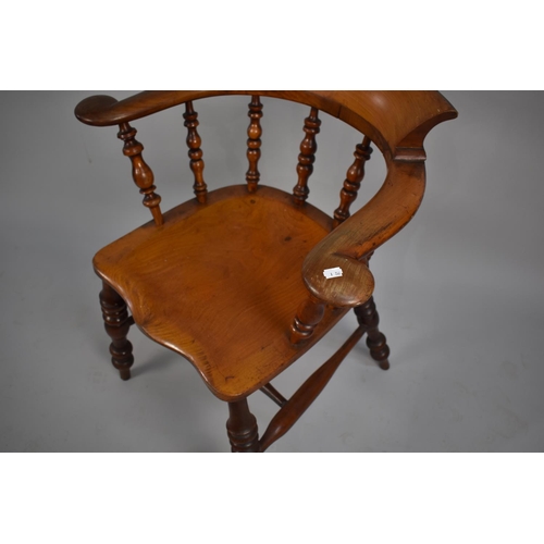 466 - A 19th Century Elm Seated Captains Chair, with spindle back and turned legs to central stretcher