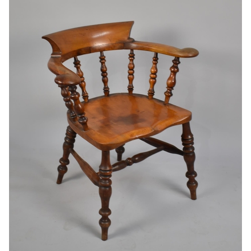 465 - A 19th Century Elm Seated Captains Chair, with spindle back and turned legs to central stretcher