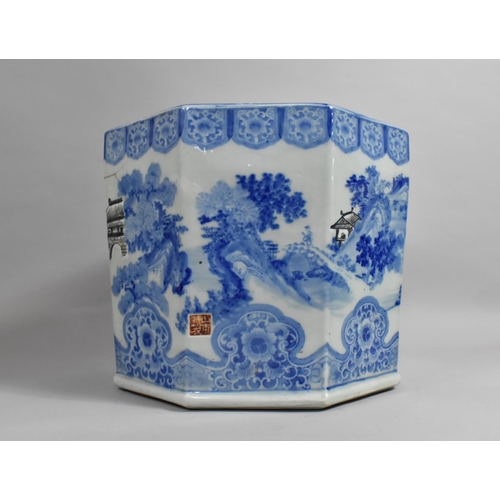 A Large Chinese Blue and White Hexagonal Porcelain Planter Decorated with Village River Scene Having Black Enamel Highlights, Red Seal Mark to Side and Precious Objects Trim to Rim, 37cm Diameter Max and 31cm high, Condition Issues