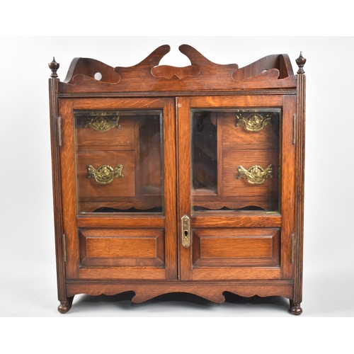 6 - An Edwardian Oak Glazed and Galleried Smokers Cabinet, with Panelled Doors each having Inner Pipe Ra... 