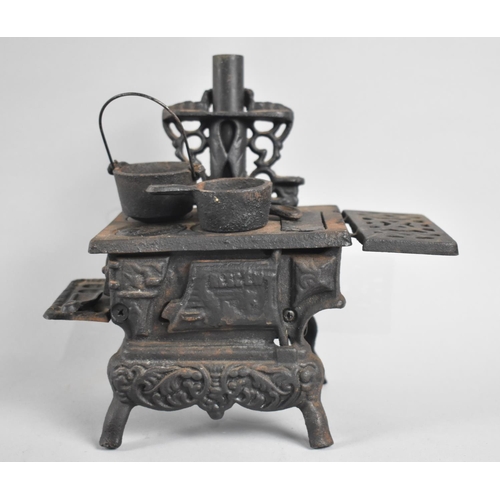 84 - A Miniature Cast Iron Model of a Cooking Stove with Two Saucepans and a Frying Pan, 21cms Long