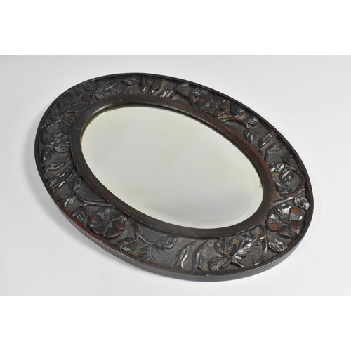 212 - An Edwardian Carved Oval Mirror, 42.5cms High