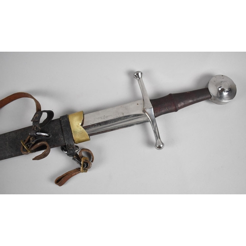 62 - A Reproduction Broad Sword in Brass Mounted Leather Scabbard