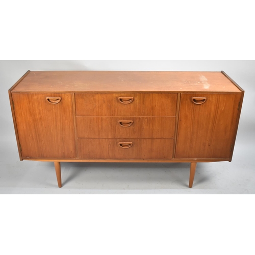 494 - A 1970's Teak Sideboard with Three Centre Drawers Flanked by Cupboards, 138cm wide, Damaged Top