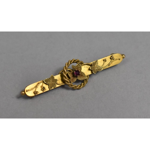 451 - A 9ct Gold Bar Brooch Having Central Ruby and Applied Leaf Design, 4.5cm wide, 2.4g