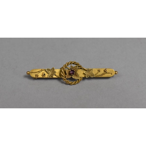 451 - A 9ct Gold Bar Brooch Having Central Ruby and Applied Leaf Design, 4.5cm wide, 2.4g