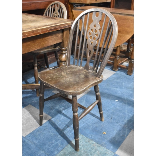 512 - An Oak Draw Leaf Dining Table together with Four Hoop Backed Dining Chairs