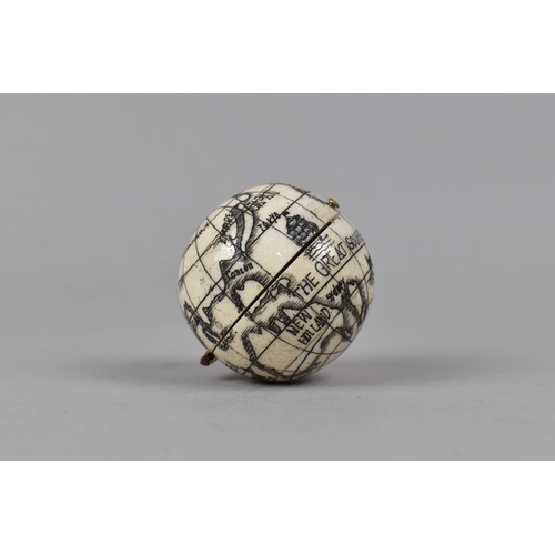 121 - A Reproduction Small Bone Scrimshaw Style Compass in the form of a Hinged Globe, 3.5cm Diameter