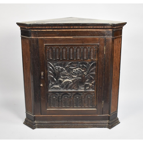 519 - A 19th Century Carved Oak Corner Cabinet with Carved Door Decorated with Welsh Dragons, 78cm wide an... 