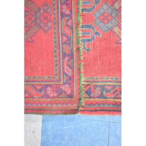 559 - A Small Patterned Rug on Red Ground, 161x89cm