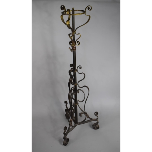 512 - A Victorian Rise and Fall Wrought Iron and Brass Oil Lamp Stand on Scrolled Tripod Support