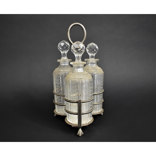 73 - An Edwardian Silver Plated Three Bottle Tantalus, Decanters with Engraved Decoration, 34cms High