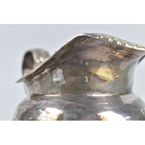 170 - A Georgian Silver Jug, London Hallmark, Although Rubbed, with Reeded Trim and Scrolled Handle, Raise... 