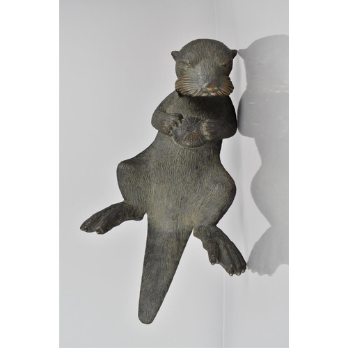 108 - Phil Vanderlei (American) A Bronze Study of an Otter, Modelled Floating on Back with Sea Urchin Held... 