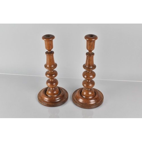 19 - A Pair of 19th Century Treen Turned Oak Candlesticks with Bobbin Turned Shafts over Circular Bases, ... 