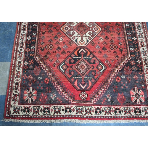 558 - A Patterned Woollen Rug on Red Ground, 168x126cms