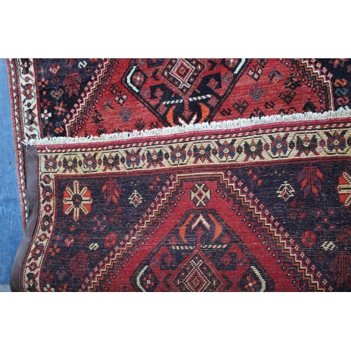 558 - A Patterned Woollen Rug on Red Ground, 168x126cms