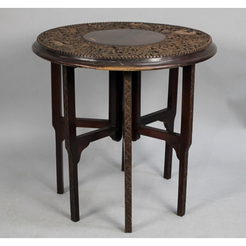 515 - An Indian Folding Table with Circular Top Having Profusely Carved Design Incorporating Elephants, Ti... 