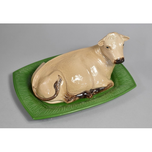 352 - A London Pottery Novelty Butter Dish and Cover in the Form of a Recumbent Cow on Green Stylised Gras... 