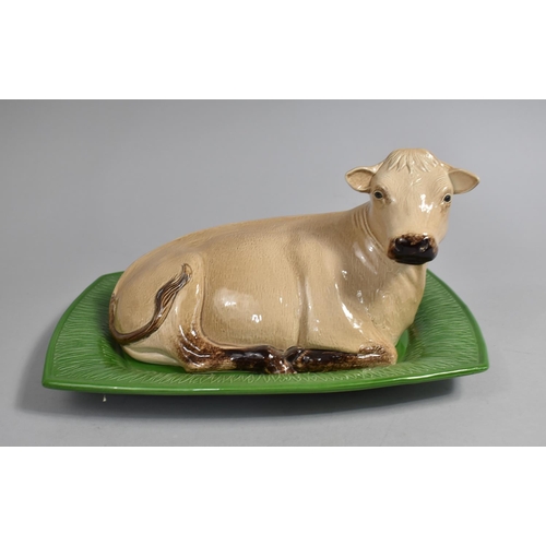 352 - A London Pottery Novelty Butter Dish and Cover in the Form of a Recumbent Cow on Green Stylised Gras... 