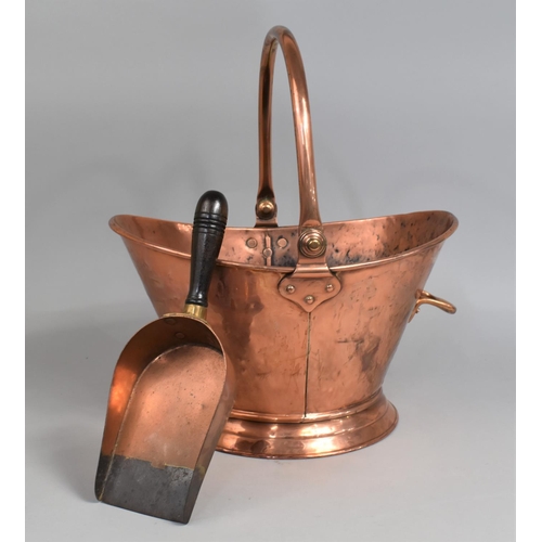 51 - A 20th Century Hand Beaten Copper Helmet Shaped Coal Scuttle and a Wooden Handled Scoop