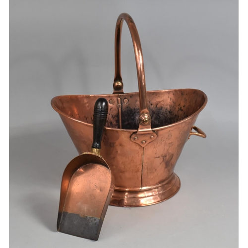 51 - A 20th Century Hand Beaten Copper Helmet Shaped Coal Scuttle and a Wooden Handled Scoop