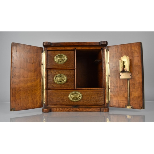 51 - A Late 19th/Early 20th Century Oak Smoker's Cabinet having Panelled Doors with Brass Handles and Loc... 