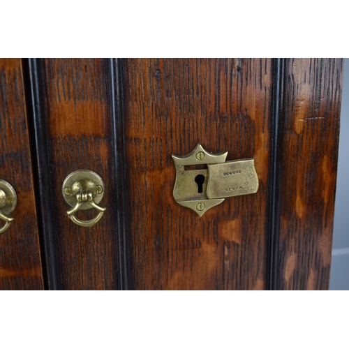 51 - A Late 19th/Early 20th Century Oak Smoker's Cabinet having Panelled Doors with Brass Handles and Loc... 