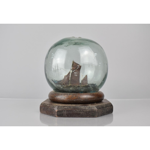 255 - A Late 19th Century Folk Art Glass Fishing Float Containing a Miniature Ships Diorama, Supported on ... 