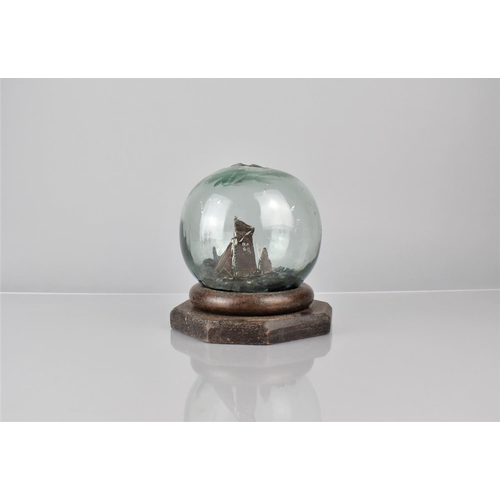 255 - A Late 19th Century Folk Art Glass Fishing Float Containing a Miniature Ships Diorama, Supported on ... 