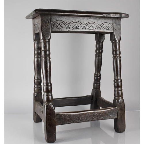 201 - An 18th Century Oak Peg Jointed Stool with Carved Seat Rail and Four Turned Supports, Top 45x25cms