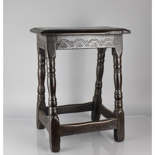 201 - An 18th Century Oak Peg Jointed Stool with Carved Seat Rail and Four Turned Supports, Top 45x25cms