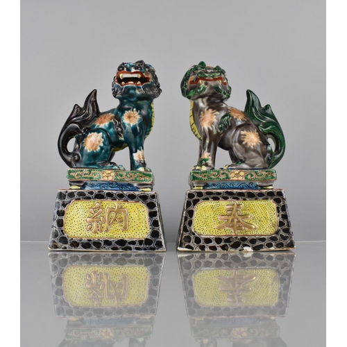 335 - A Pair of Japanese Porcelain Temple Lions on Tapering Plinth Bases decorated in Polychrome Enamels, ... 