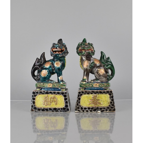 335 - A Pair of Japanese Porcelain Temple Lions on Tapering Plinth Bases decorated in Polychrome Enamels, ... 