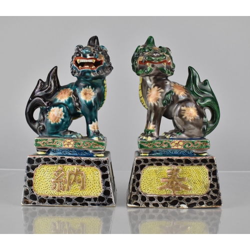 335 - A Pair of Japanese Porcelain Temple Lions on Tapering Plinth Bases decorated in Polychrome Enamels, ... 