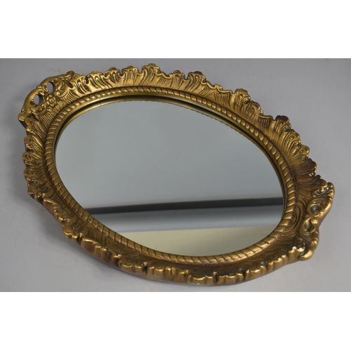 141 - A Mid 20th Century Gilt Plaster Oval Wall Mirror, 47cms High