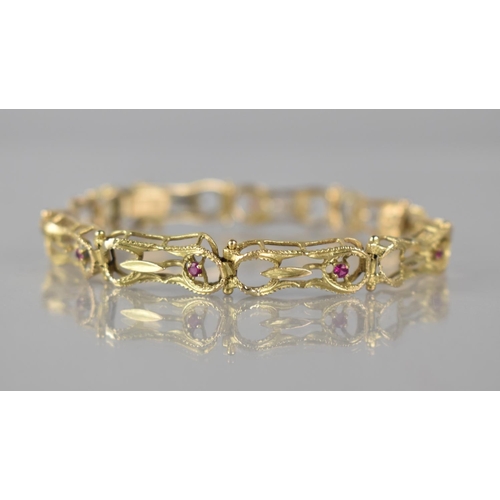 131 - A 14ct Gold and Ruby Nine Panel Wirework Bracelet, Pressed and Textured Figure of Eight Wire Frames,... 