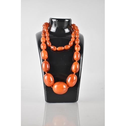 242 - A Long String of Vintage Orange Bakelite Oval Beads, Largest Measuring 32mm Long and 25mm Diameter, ... 