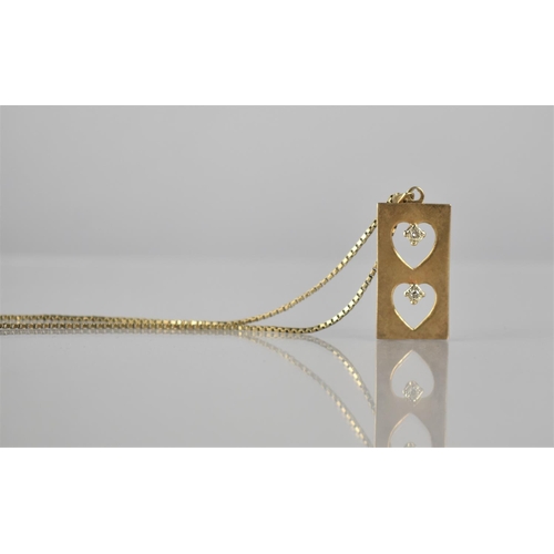 132 - A 9ct Gold and Diamond Pendant on a 9ct Gold Box Chain, Two Pierced Hearts Surmounted by Two Illusio... 