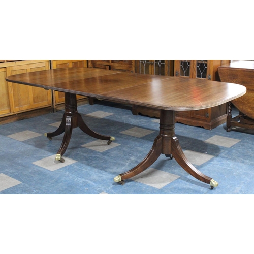 324 - A Twin Pedestal Extending Dining Table With Crossbanding to Top and Brass Claw Feet with Castors