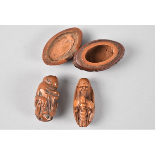 18 - A collection of two miniature oriental carved nut netsukes together with a miniature carved nut ovoi... 