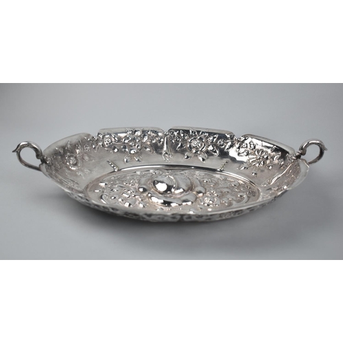 318 - An Alpaca Metal Repousse Rose Decorated Oval Dish with Twin Handle, Stamped to Base, 33cm wide