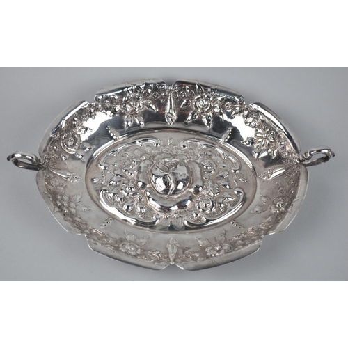 318 - An Alpaca Metal Repousse Rose Decorated Oval Dish with Twin Handle, Stamped to Base, 33cm wide