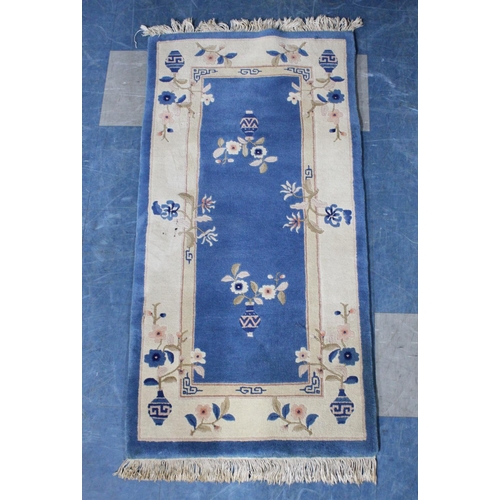 427 - A Chinese Patterned Woollen Rug on Blue Ground, 140x71cm