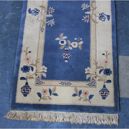 427 - A Chinese Patterned Woollen Rug on Blue Ground, 140x71cm