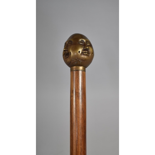 131 - A Modern Turned Wooden Walking Cane with Bronze Four Sided Buddha Handle