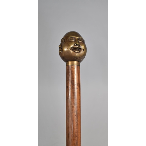 131 - A Modern Turned Wooden Walking Cane with Bronze Four Sided Buddha Handle